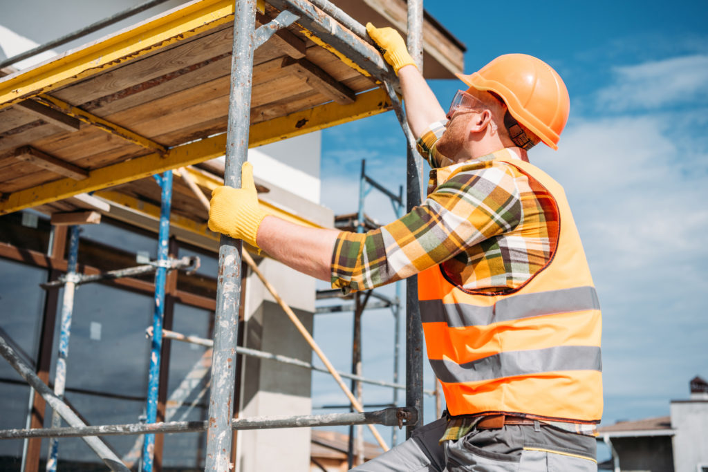 Builder climbing scaffolding